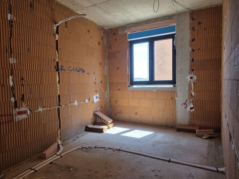 CHORVÁTSKO - Apartmány 2.rad od mora - SRIMA, VODICE - Nedokončená izba v 3-izbovom byte s odkrytými tehlovými stenami a oknom.