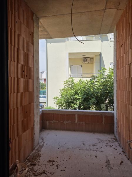CHORVÁTSKO - Apartmány 2.rad od mora - SRIMA, VODICE - Nedokončený balkón v 3-izbovom byte s pohľadom na zeleň a vedľajšiu budovu.