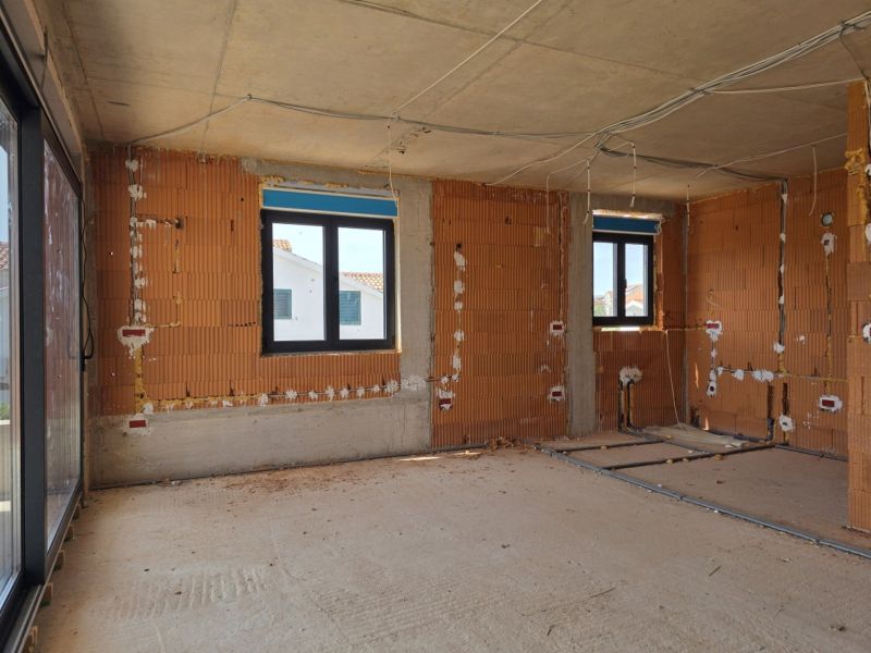 CHORVÁTSKO - Apartmány 2.rad od mora - SRIMA, VODICE - Interiér 3-izbového bytu vo výstavbe s holými tehlovými stenami a plastovými oknami.