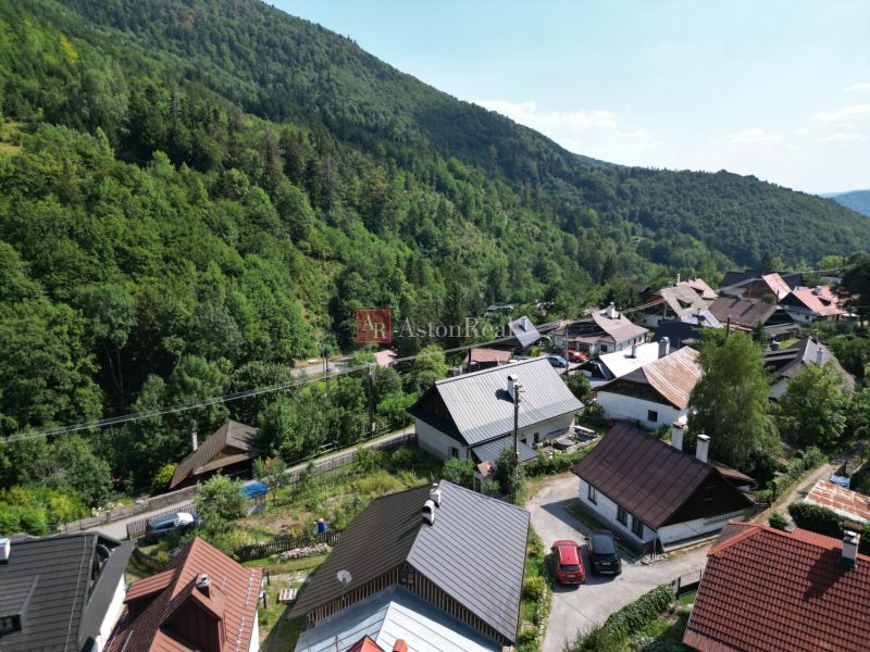 Predaj: Štýlová chalupa v srdci Španej Doliny miesto s atmosférou  - Pohľad na malebné chalupy v Španej Doline neďaleko Banskej Bystrice, obklopené hustými lesmi.