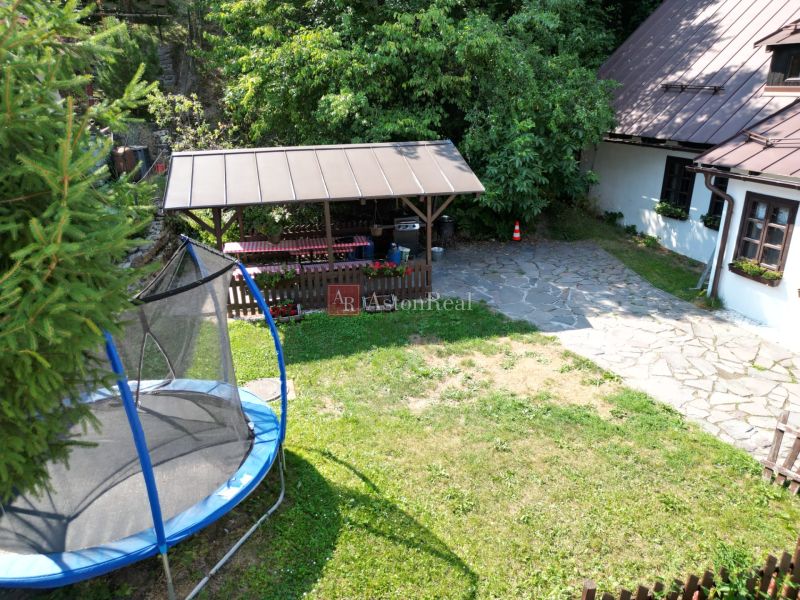 Predaj: Štýlová chalupa v srdci Španej Doliny miesto s atmosférou  - Dvor chaty na ulici Špania Dolina v Banskej Bystrici s trampolínou a altánkom.