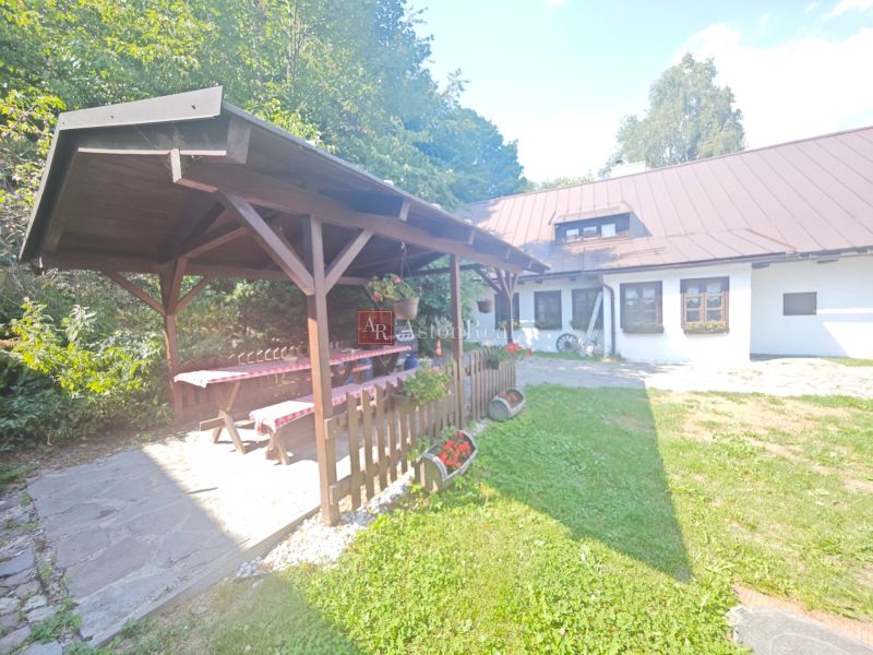 Predaj: Štýlová chalupa v srdci Španej Doliny miesto s atmosférou  - Chata v Španej Doline s altánkom, dreveným stolom a kvetinovou výzdobou na záhrade.