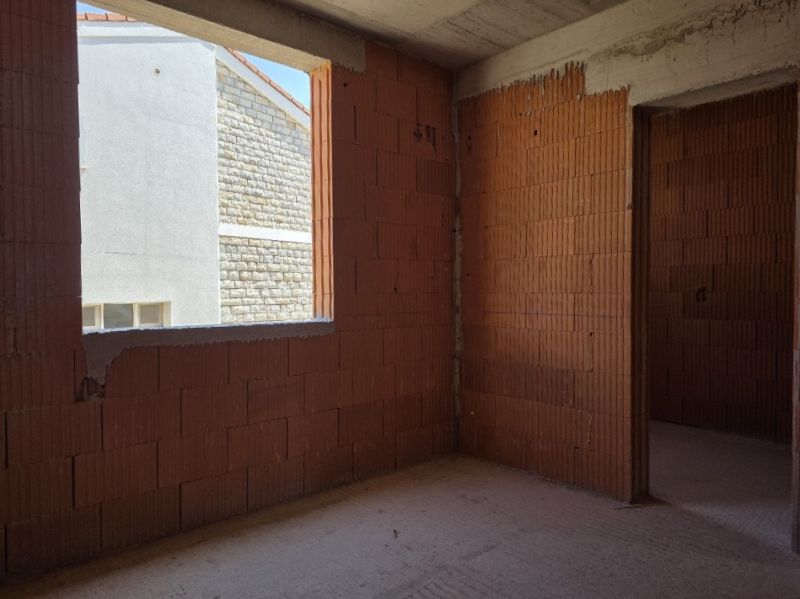 CHORVÁTSKO -  Apartmány v 1. rade od mora - SRIMA, VODICE - Nedokončený stavebný interiér s tehlovými stenami a otvorom na okno, bez podlahy.