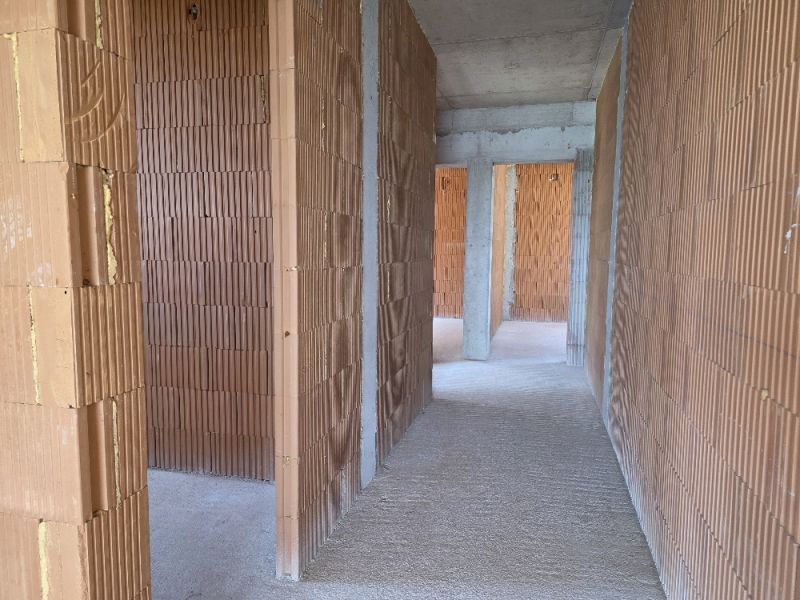 CHORVÁTSKO -  Apartmány v 1. rade od mora - SRIMA, VODICE - Interiér 4-izbového bytu s holými tehlovými stenami a cementovou podlahou.