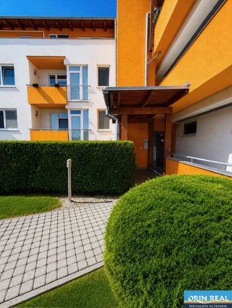 Krásny priestranný klimatizovaný 1izbový byt s terasou 66m2 - Farebná fasáda budovy obklopená zelenými kríkmi na Čerešňovej ulici v Chorvátskom Grobe.