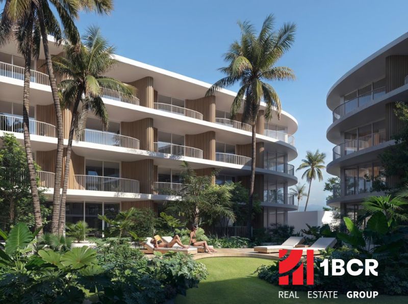 THE CORAL KOH SAMUI - Výstavba bytov v Surat Thani: apartmánové budovy s palmami a zeleňou na pozadí.