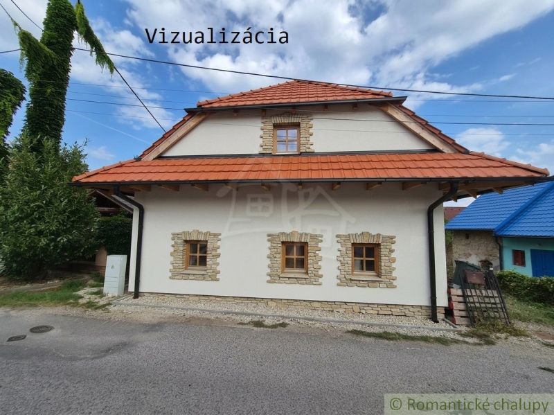 Dom s chalupárskou atmosférou s nadstavbou v peknom prostredí v obci Š - Rodinný dom v Šútovciach s červenou strechou a štyrmi oknami v kamennom orámovaní.