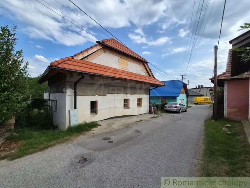 Dom s chalupárskou atmosférou s nadstavbou v peknom prostredí v obci Š - Rodinný dom v Šútovciach s červenou škridlovou strechou pri úzkej ulici.