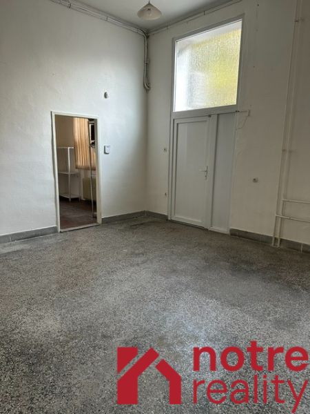 Na prenájom reprezentatívne nebytové priestory v centre mesta Lučenec - Interiér kancelárie s bielymi stenami a podlahou v dekoru betónového efektu.