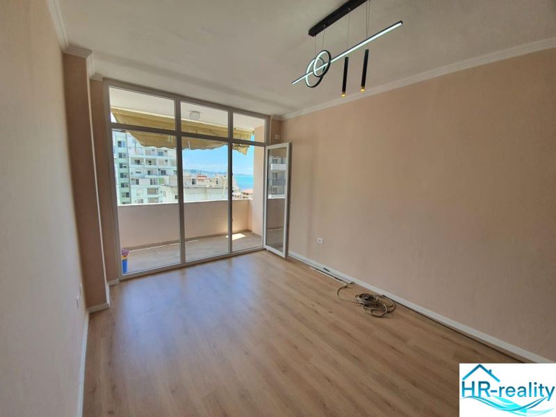 Albánsko, Drač - zrekonštruovaný byt  s výhľadom na more - Rekreačný apartmán s presklenou stenou a podlahou s dreveným dekorom, vstup na balkón.