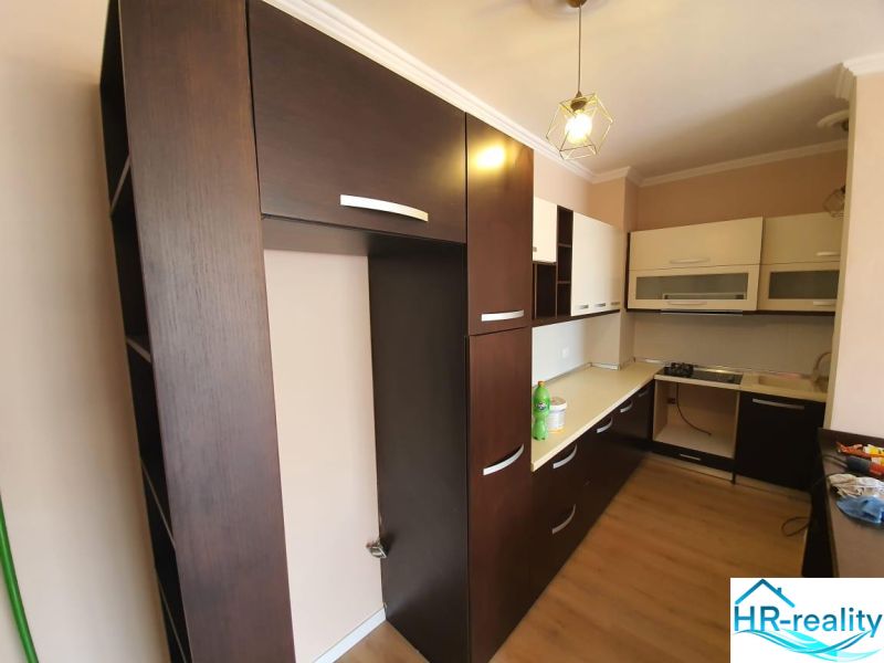 Albánsko, Drač - zrekonštruovaný byt  s výhľadom na more - Kuchyňa v Rekreačnom apartmáne, dominujú tmavé skrinky a podlaha s dreveným dekorom.