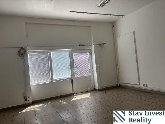 Obchodný priestor na prenájom priamo v centre Sládkovičova   - Interiér obchodných priestorov s veľkými oknami a podlahou z dlaždíc.