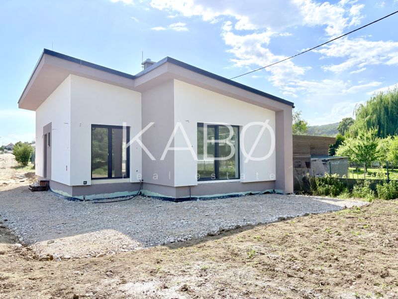 Novostavba moderného 4i rodinného domu v Štitároch - Rodinný dom v Štitároch s priestrannými oknami a zeleným okolím na pozemku.