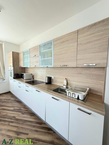 Na prenájom luxusný 3 izb. byt s garážou v Panorama City, Staré Mesto. - Kuchynská linka s bielymi skrinkami a podlahou s dreveným dekorom v 3-izbovom byte.