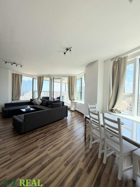 Na prenájom luxusný 3 izb. byt s garážou v Panorama City, Staré Mesto. - Svetlá obývacia izba s pohovkou a podlahou s dreveným dekorom, 3-izbový byt.