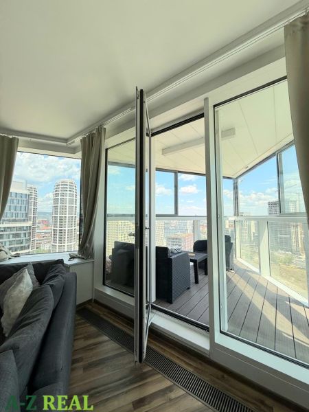 Na prenájom luxusný 3 izb. byt s garážou v Panorama City, Staré Mesto. - Obývacia izba so sedačkou a prístupom na balkón v 3-izbovom byte s výhľadom.