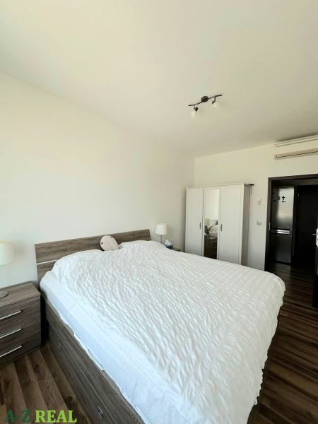 Na prenájom luxusný 3 izb. byt s garážou v Panorama City, Staré Mesto. - Spálňa s dvojlôžkom, šatníkovou skriňou a podlahou s dreveným dekorom v 3-izbovom byte.