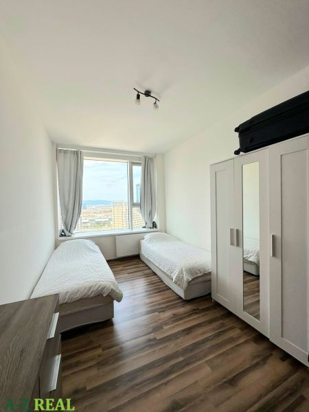Na prenájom luxusný 3 izb. byt s garážou v Panorama City, Staré Mesto. - Izba s dvoma posteľami a skriňou, podlaha s dreveným dekorom v 3-izbovom byte.
