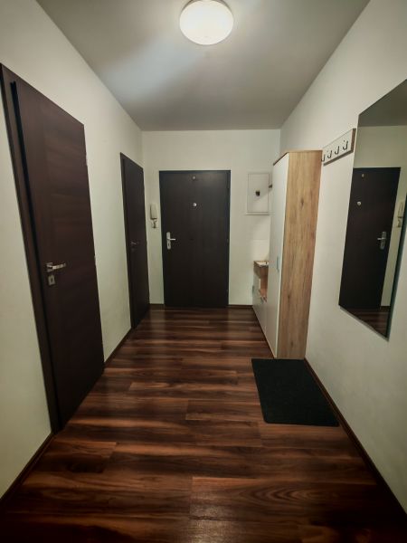 Moderný 2- izbový byt na prenájom , Rohožník - Vstupná hala 2-izbového bytu s podlahou s dreveným dekorom a vešiakom.