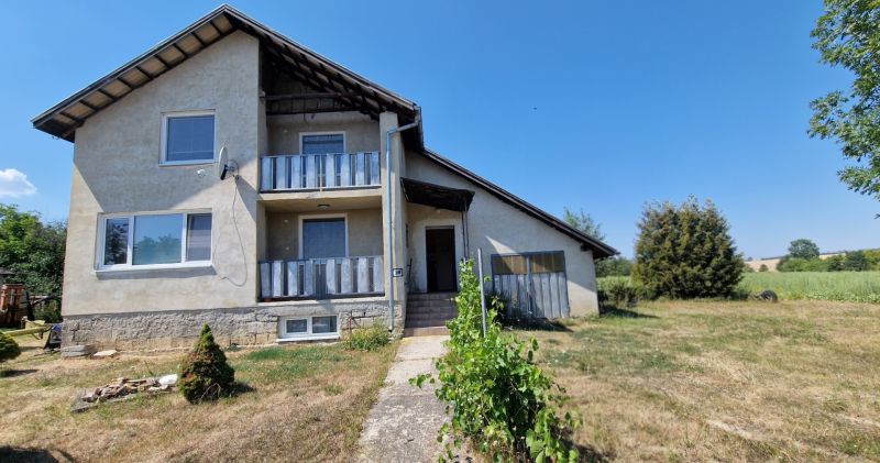 Na predaj dvojpodlažný rodinný dom v obci Kazimír, okres Trebišov - Rodinný dom na ulici Biela v Kazimíri, obklopený rozľahlou záhradou a modrou oblohou.