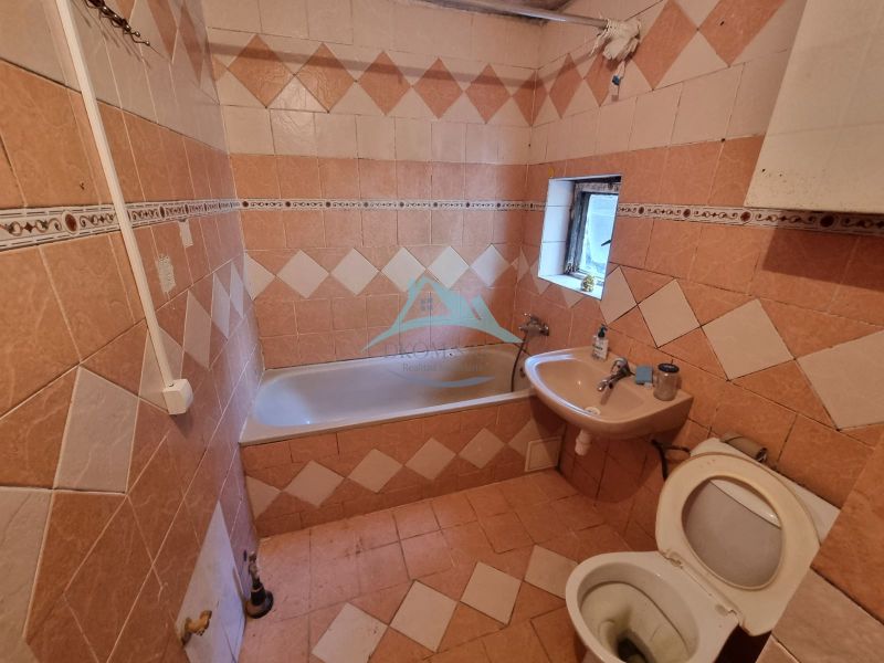 Dvojgeneračný rodinný dom s obrovským potenciálom v Šahách - Kúpeľňa s dlažbou a obkladom, vaňa, umývadlo a toaleta v rodinnom dome.