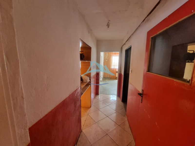 Dvojgeneračný rodinný dom s obrovským potenciálom v Šahách - Chodba v rodinnom dome s kachličkovou podlahou a červenými dverami.