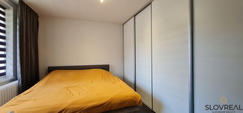 Na predaj 2i byt Levice, 49m2 - Spálňa v 2-izbovom byte s bielymi skriňami a žltou perinou.