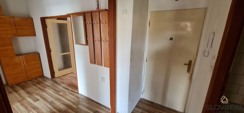 Na predaj 2i byt Levice, 48m2 - Vstupná hala v 2-izbovom byte s podlahou s dreveným dekorom a vešiakovým panelom.