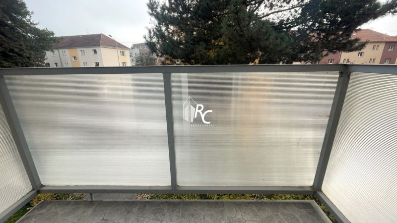 Prenájom 2-izbový byt s balkónom Martin – Podháj (41m2) - Balkón s nepriehľadným zábradlím a výhľadom na stromy a bytovky na Gorkého ulici v Martine.