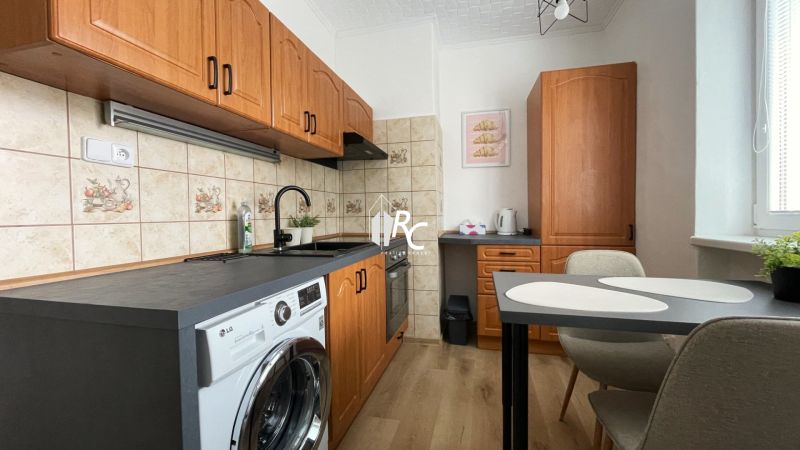 Prenájom 2-izbový byt s balkónom Martin – Podháj (41m2) - Kuchyňa v 2-izbovom byte s podlahou s dreveným dekorom a linkou so spotrebičmi.