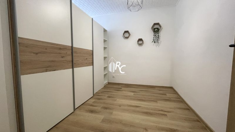 Prenájom 2-izbový byt s balkónom Martin – Podháj (41m2) - Izba v 2-izbovom byte s podlahou s dreveným dekorom a vstavanou skriňou.