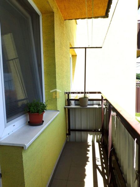Veľkometrážny 3-izbový byt Smrdáky - Balkón v 3-izbovom byte s kvetináčmi a bielym parapetom.