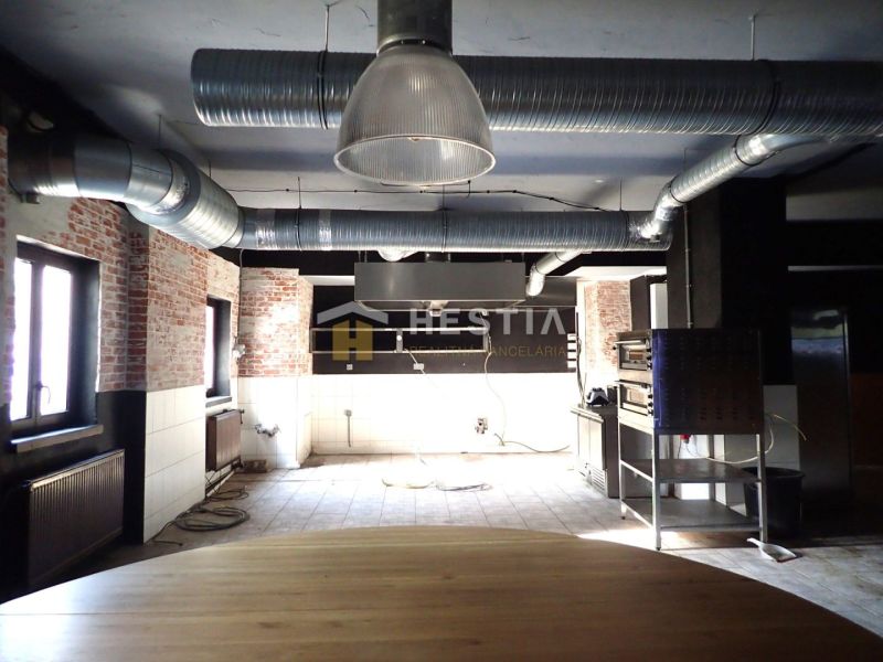 Reštaurácia s terasou na prenájom – centrum mesta - Interiér obchodných priestorov s viditeľným tehlovým múrom a vzduchotechnikou na strope.
