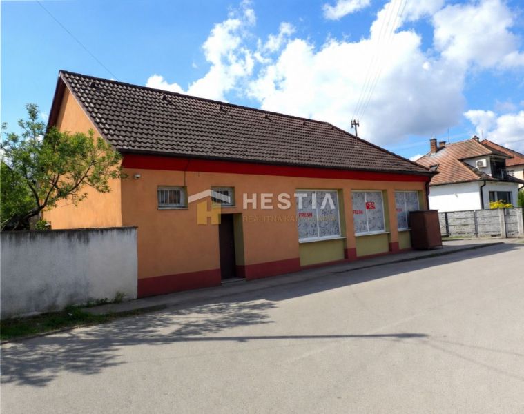 Podnikateľský objekt s pozemkom na predaj Borský Mikuláš - Rodinný dom v Borskom Mikuláši s oranžovou fasádou a hnedou strechou.