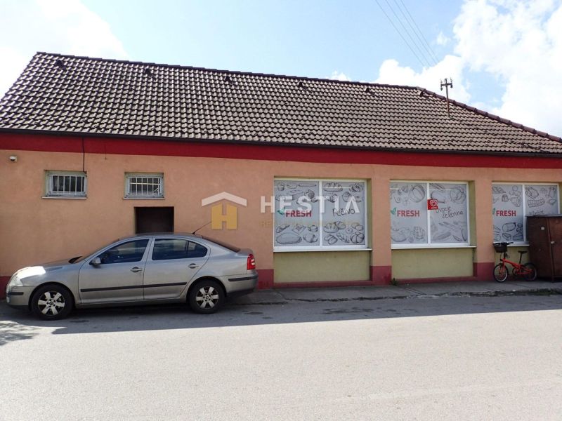 Podnikateľský objekt s pozemkom na predaj Borský Mikuláš - Rodinný dom v Borskom Mikuláši má tehlovú fasádu, vedľa je zaparkované auto.