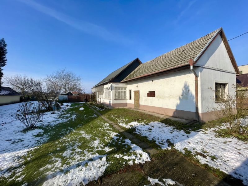 REZERVOVANÝ-VRAKÚŇ – STARÝ RODINNÝ DOM NA PREDAJ S VEĽKÝM POZEMKOM - 2 - Rodinný dom vo Vrakúni obklopený záhradou s trávnikom a zvyškami snehu.