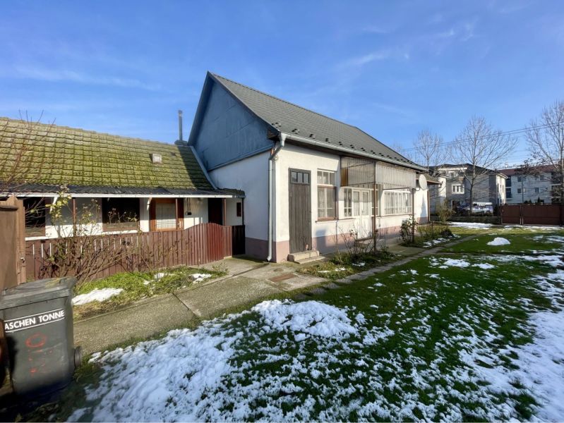 REZERVOVANÝ-VRAKÚŇ – STARÝ RODINNÝ DOM NA PREDAJ S VEĽKÝM POZEMKOM - 2 - Rodinný dom vo Vrakúni s trávnikom, zvyškami snehu a vedľajšou drevenou stavbou.