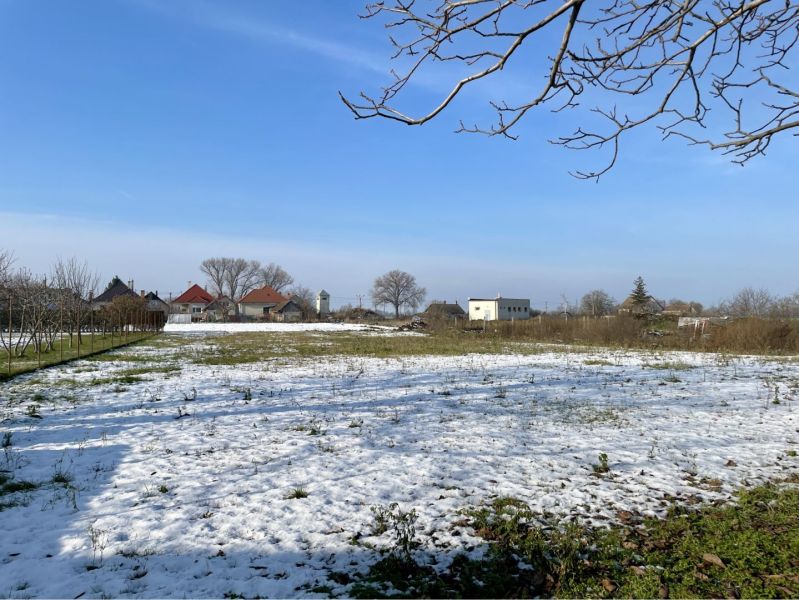 REZERVOVANÝ-VRAKÚŇ – STARÝ RODINNÝ DOM NA PREDAJ S VEĽKÝM POZEMKOM - 2 - Zasnežený pozemok vo Vrakúni so stromami a domami v pozadí. Pozemky - bývanie.