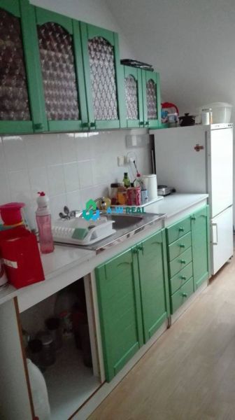 DUNAJSKÁ STREDA - KANCELÁRSKY PRIESTOR NA PRENÁJOM - Kuchyňa s bielou pracovnou doskou, zelenými skrinkami a podlahou s dreveným dekorom.