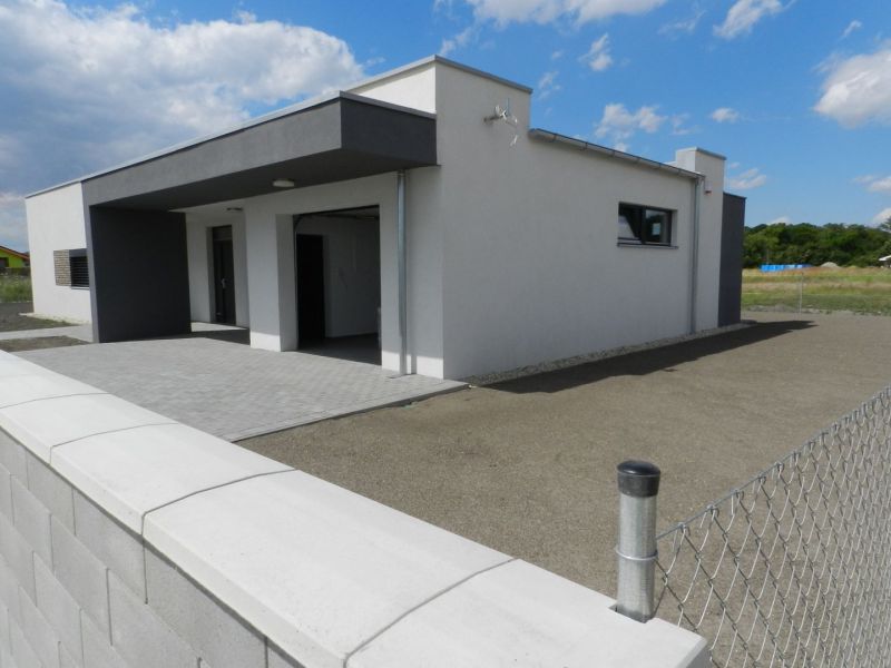 4. ETAPA!!! MODERNÁ NOVOSTAVBA - 3 izbový nízkoenergetický bungalov vy - Rodinný dom v Dolnom Bare s plotom a spevnenou plochou pod modrou oblohou.