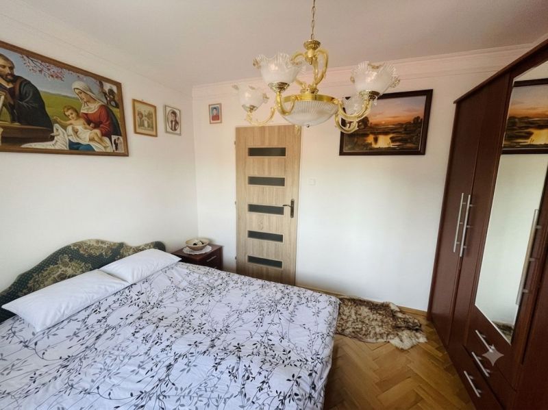 Exkluzívne na PREDAJ, zrekonštruovaný 3 izb.byt, Ružový háj, Dunajská  - Spálňa v 3-izbovom byte s obrazmi, šatníkom a lustrom, podlaha s dreveným dekorom.