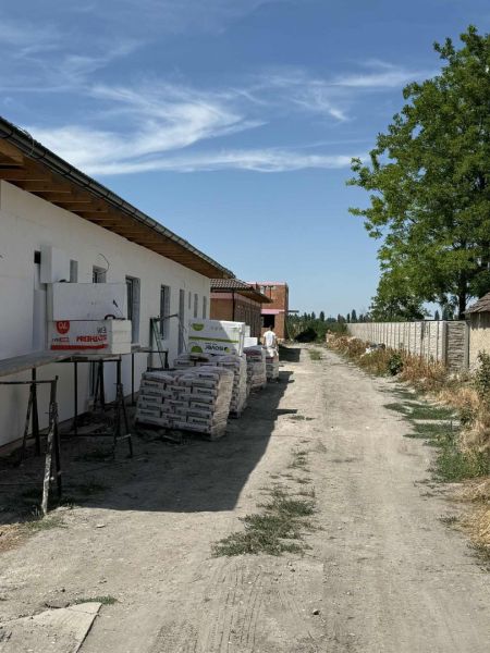 Už toto leto vo Vlastnom s tepelným čerpadlom v cene - Stavba rodinného domu na ulici Padáň v Padáni, s materiálmi a modrou oblohou.