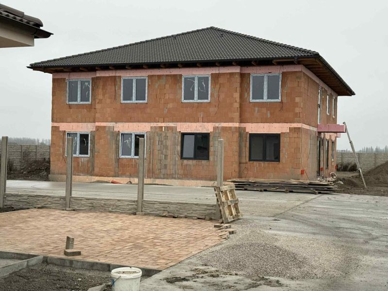Nová štvorbytovka v tichom prostredí iba 10km od Dunajskej Stredy v ob - Stavebný objekt v meste Padáň bez omietky, vedľa je betónová cesta.