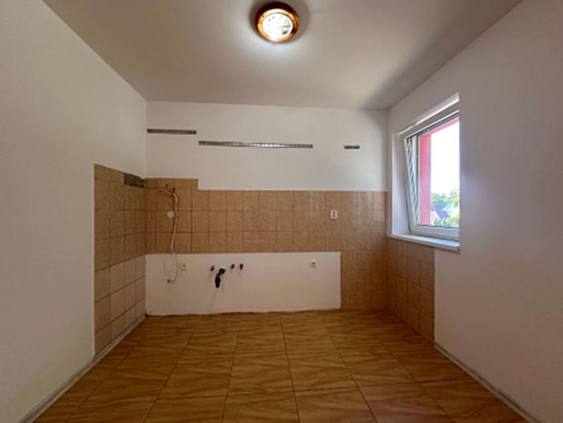 ☎️ 0918/197 701 NA PREDAJ 3-izbový byt v Lehniciach s vlastným kúrením - Nezariadená kuchyňa v 3-izbovom byte s dlažbou a obkladmi, veľké okno poskytuje svetlo.