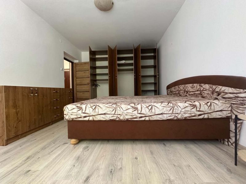 ☎️ 0918197701 Na prenájom  zariadený 1 izbový byt  na sídlisku západ n - Spálňa v 1-izbovom byte s posteľou, otvorenou skriňou a podlahou s dreveným dekorom.