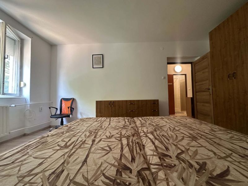 ☎️ 0918197701 Na prenájom  zariadený 1 izbový byt  na sídlisku západ n - Spálňa v 1-izbovom byte s posteľou, skriňou a stoličkou, podlaha s dreveným dekorom.
