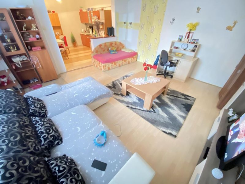 ☎️ 0918197701-NA PREDAJ  APARTMÁNOVÝ  DOM V KÚPEĽNOM MESTE  VO VEĽKOM  - Obývacia izba v rodinnom dome s pohovkou, stolom, TV a dekoráciami, podlaha s dreveným dekorom.