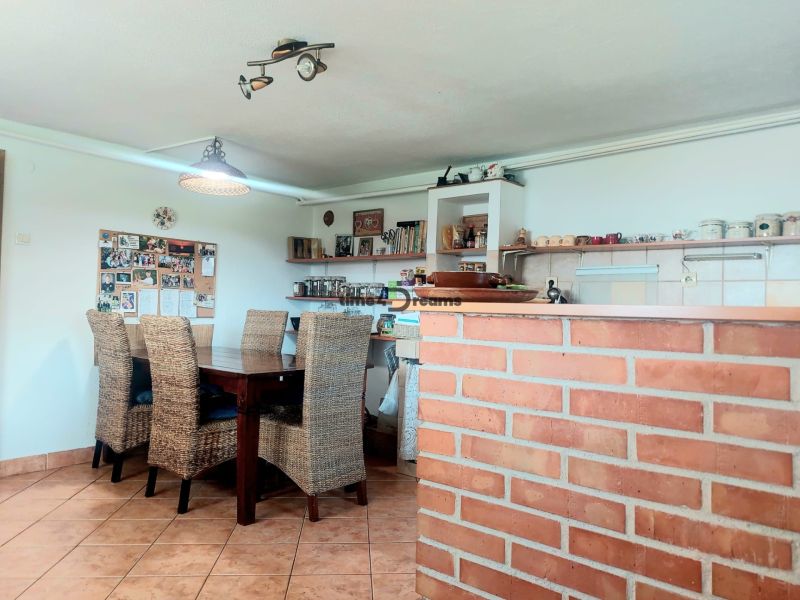  NA PREDAJ Priestranný rodinný dom s farmou  Detva - Jedáleň rodinného domu s tehlovým barom, ratanovými stoličkami a nástenkou s fotografiami.