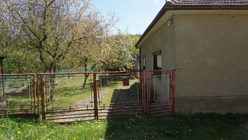 NA PREDAJ – chalupa alebo rodinný dom na pokojné bývanie  - Rodinný dom v Krajnom so záhradou a bránou obklopený stromami a trávnikom.
