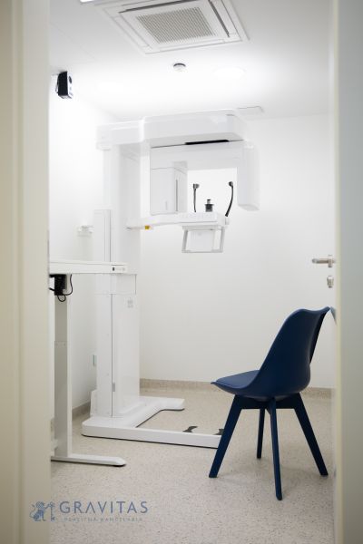 Kompletne zariadená zubná ambulancia, Záhorská Bystrica - Izba s röntgenovým prístrojom a modrou stoličkou v obchodných priestoroch.